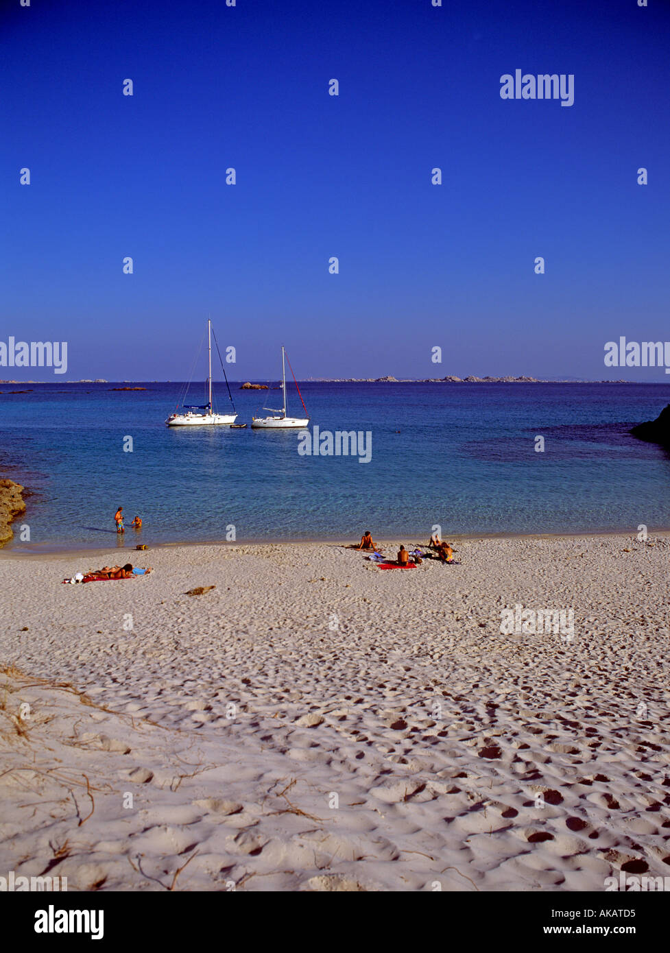 Meer, Sand und Spaß Menschen am Strand mit Yachten ankern in der Bucht Korsika Frankreich Mittelmeer Stockfoto