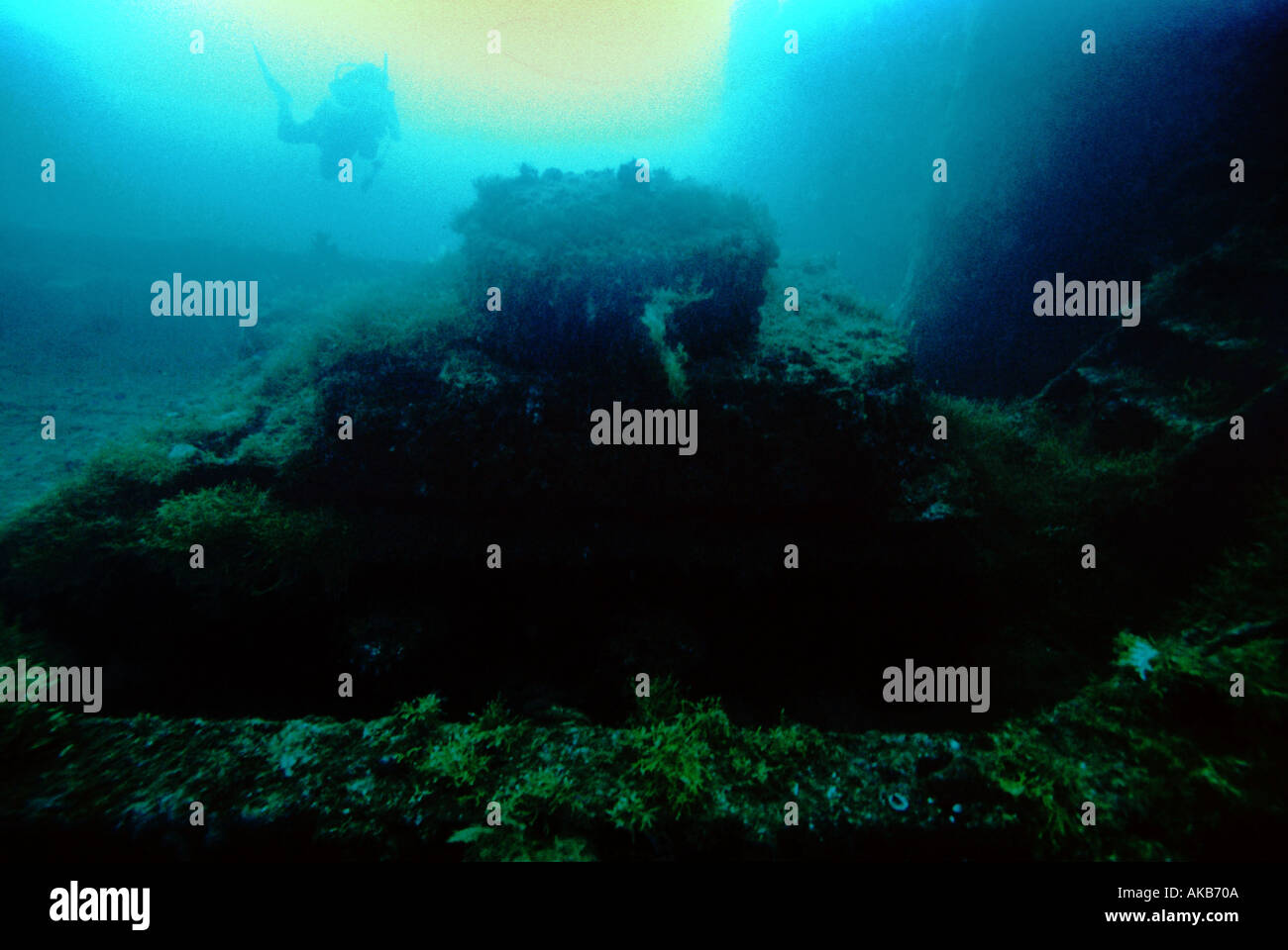 Ein Taucher ist Silhouette, wie sie nähert sich einen Panzer untergetaucht im Sediment auf das Schiffswrack der Nipo Maru Truk Lagoon Mikronesien Stockfoto