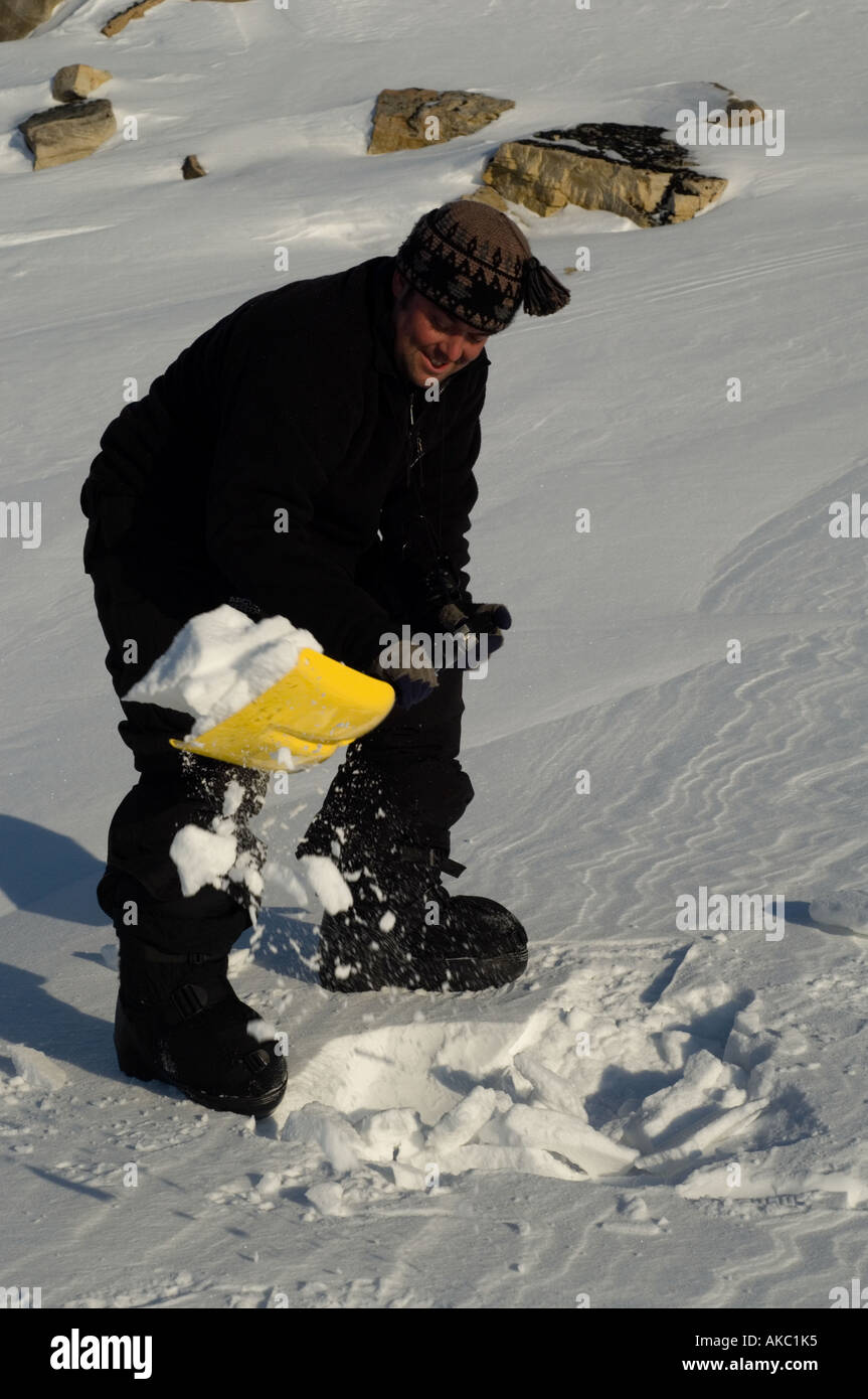 Qaanaaq Grönland Graben im Schnee mit einer Schaufel, Camping Toilette machen Stockfoto