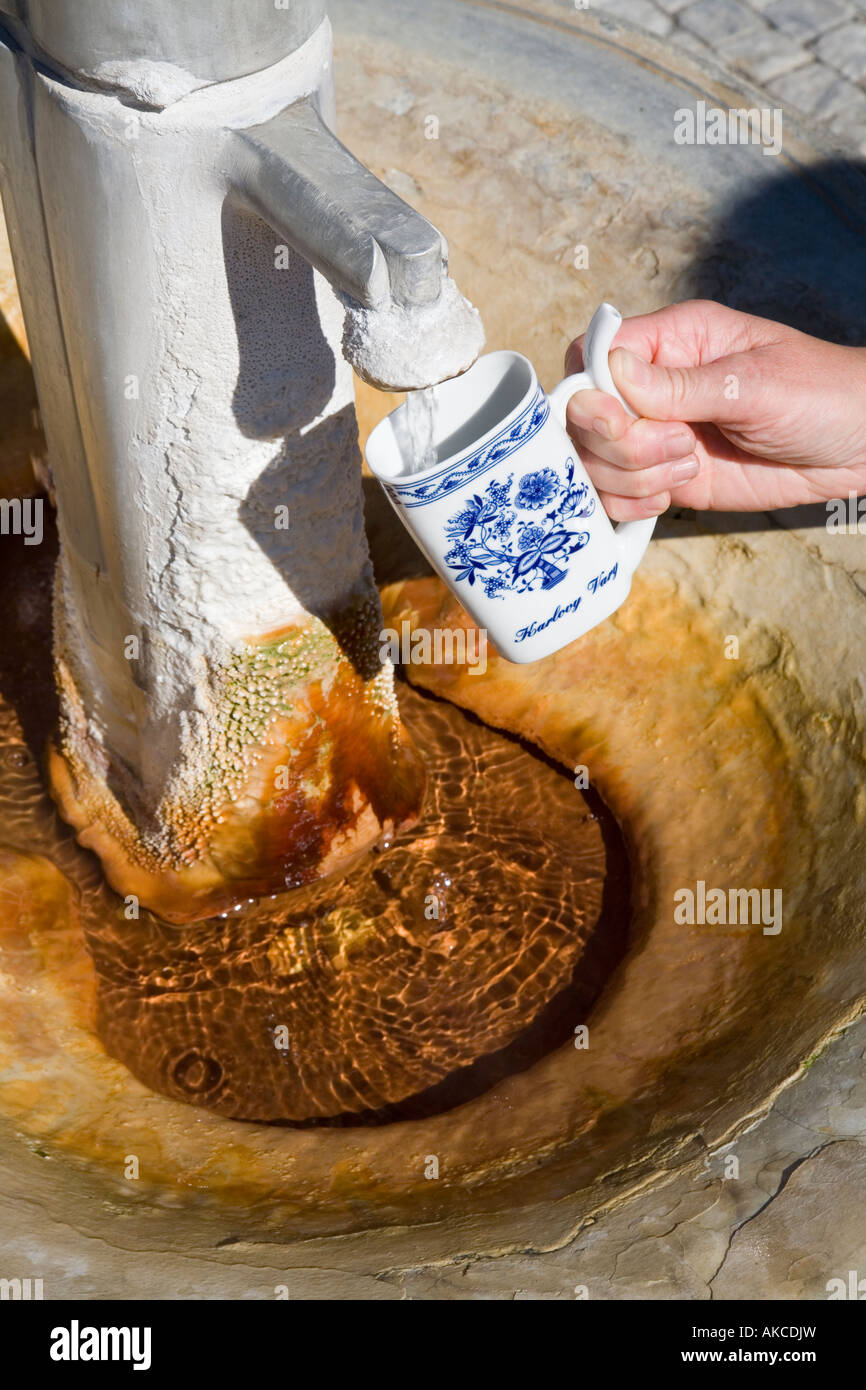 Füllen ein Trinkbecher aus heißen Mineralquelle bei Mlynska Kolonada in Karlovy Vary, Tschechische Republik Stockfoto