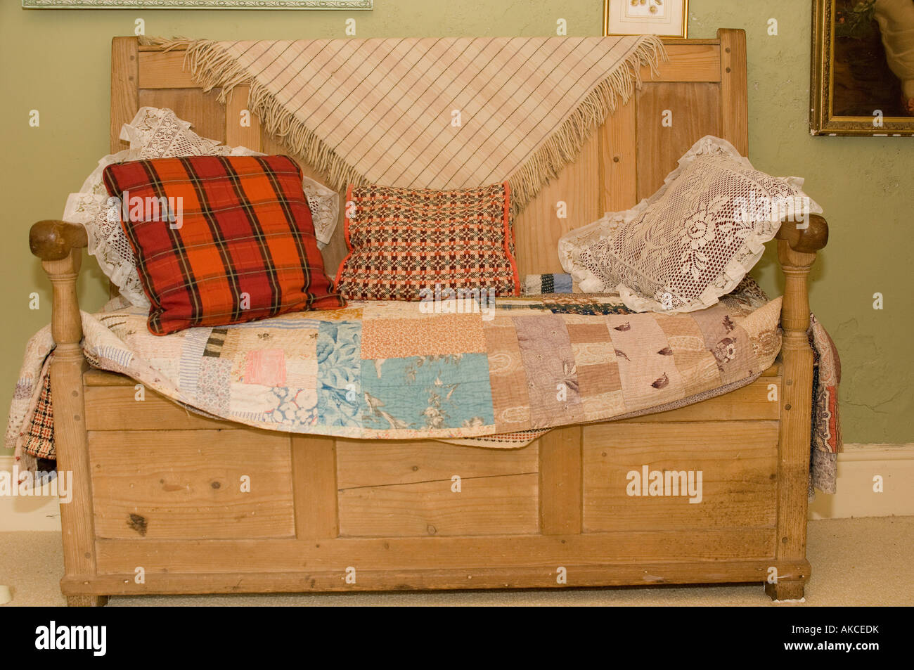 walisische Holz Kiefer Settle Sitzbank mit Kissen und Patchwork Quilts im  Landhaus Stockfotografie - Alamy