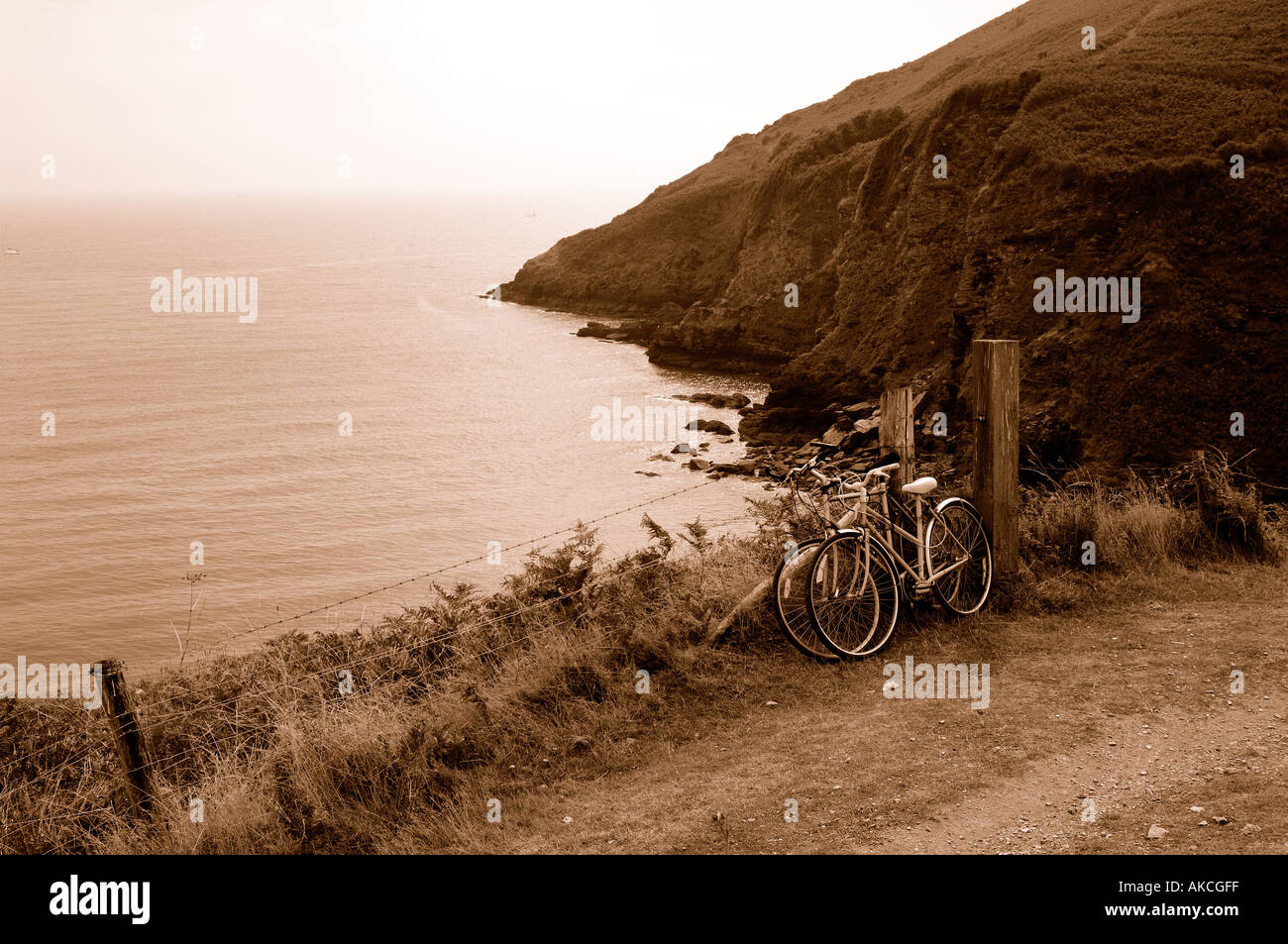 Schön getönten Sepia Bild von zwei Fahrrädern lehnte sich gegen einen Zaun entlang der South West Coast Path sehr erinnert an eine vergangene Ära Stockfoto