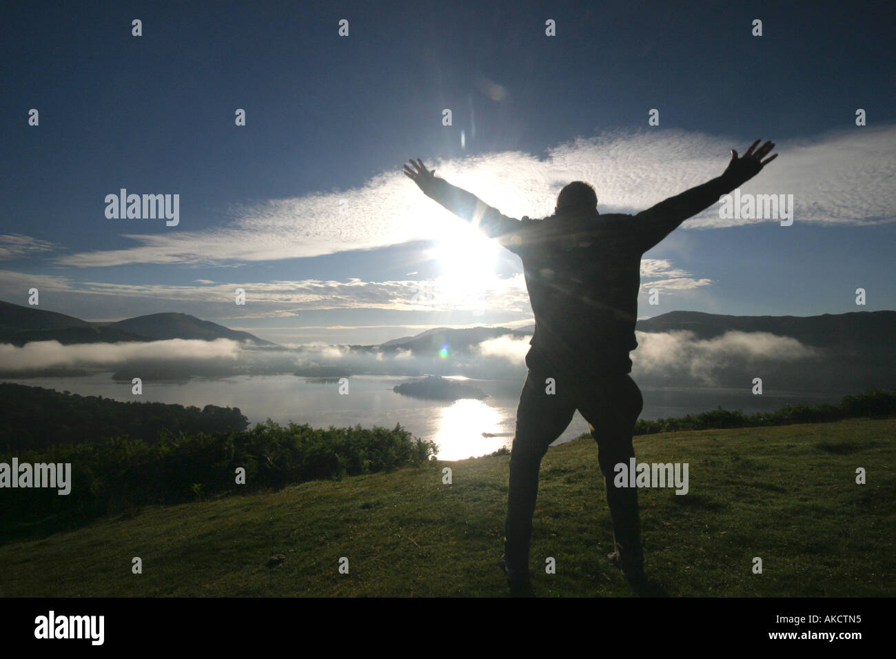 Ein stock Foto eines Mannes springen auf einem Berg bei Sonnenaufgang Stockfoto