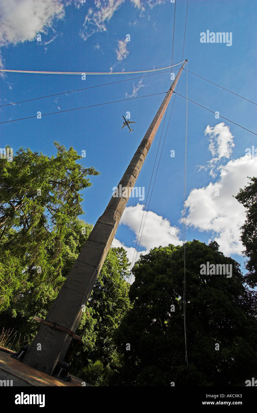Die Fahnenstange am Kew Gardens London und einem vorbeifahrenden Passagierjet Stockfoto