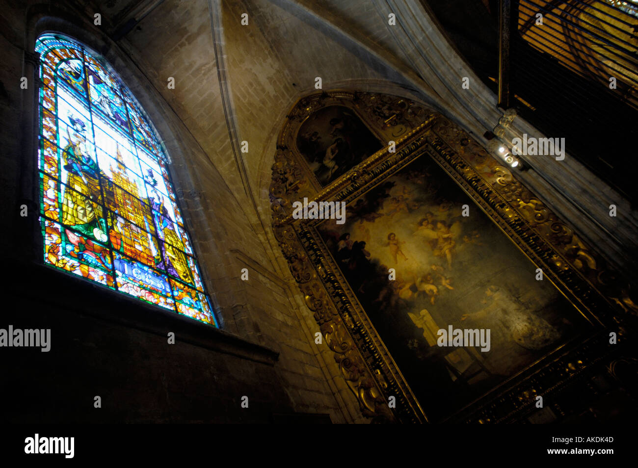 Religiöse Malerei und Glasmalerei-Fenster in einer Kapelle in der Kathedrale von Sevilla, Sevilla, Andalusien, Spanien. Stockfoto