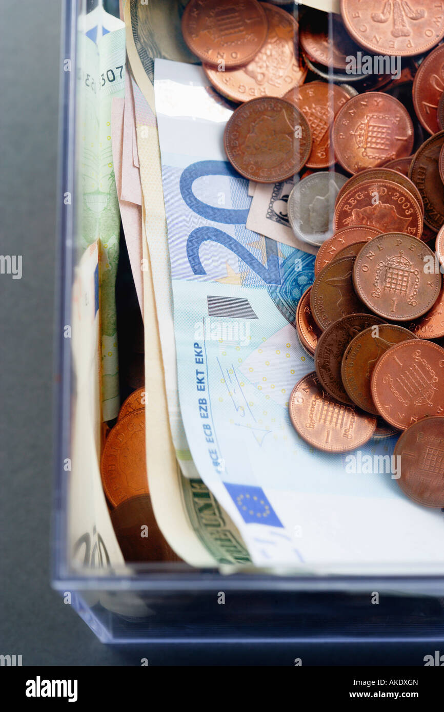 Kunststoff Sparschweinchen mit Münzen und Papier Euro-Währung, Ansicht von oben Stockfoto