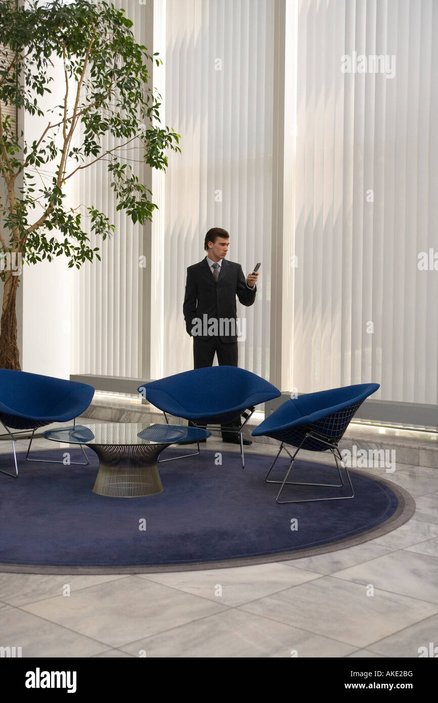 Business Man Text-messaging mit Handy im Büro lobby Stockfoto