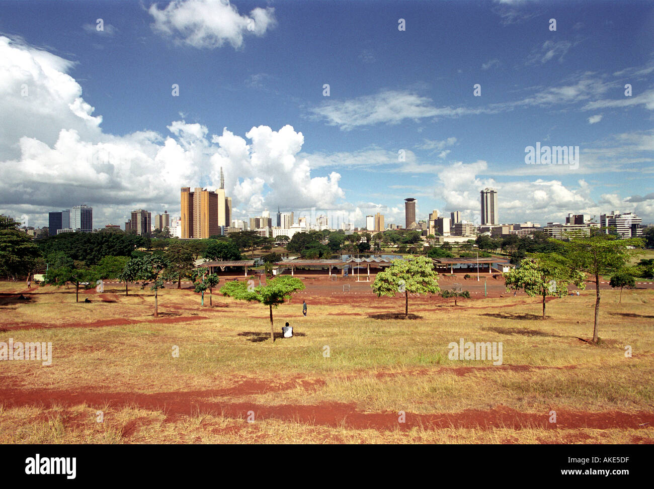 Ein Mann sitzt unter einem Baum mit Blick auf die Stadt Nairobi in Kenia in Ostafrika Stockfoto