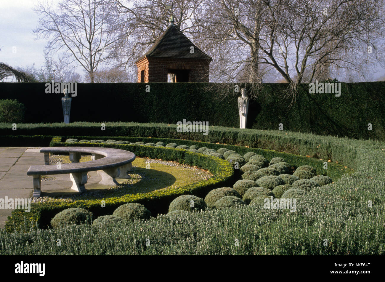 Kew Gardens Surrey Queen s Garten im Winter gebogen Steinbank Hecken Eibe Buchsbaum Rosmarin und Kamille Statuen Stockfoto