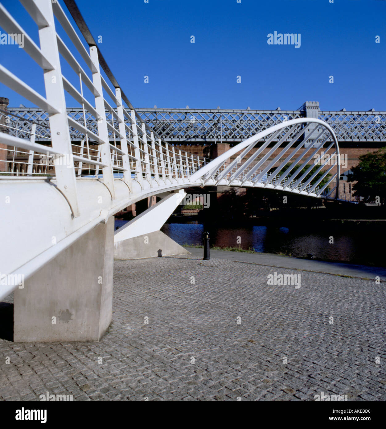 Händler Brücke (Stahlrohr geneigt arch Fußgängerbrücke), Kaufleute Quay, Castlefield Urban Heritage Park Manchester England England Stockfoto
