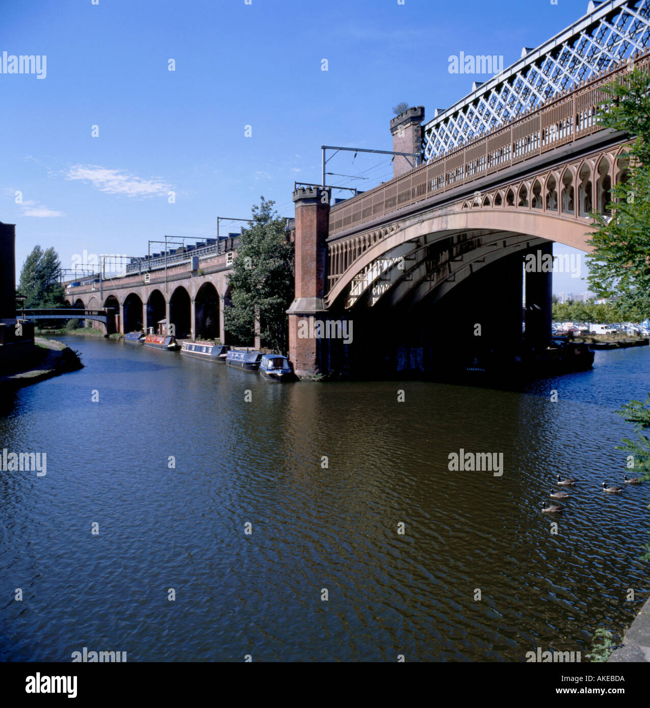 Gusseisen Bogen Eisenbahnbrücke über den Herzog von Bridgewater Kanal, Castlefield Urban Heritage Park, Manchester, England, UK. Stockfoto