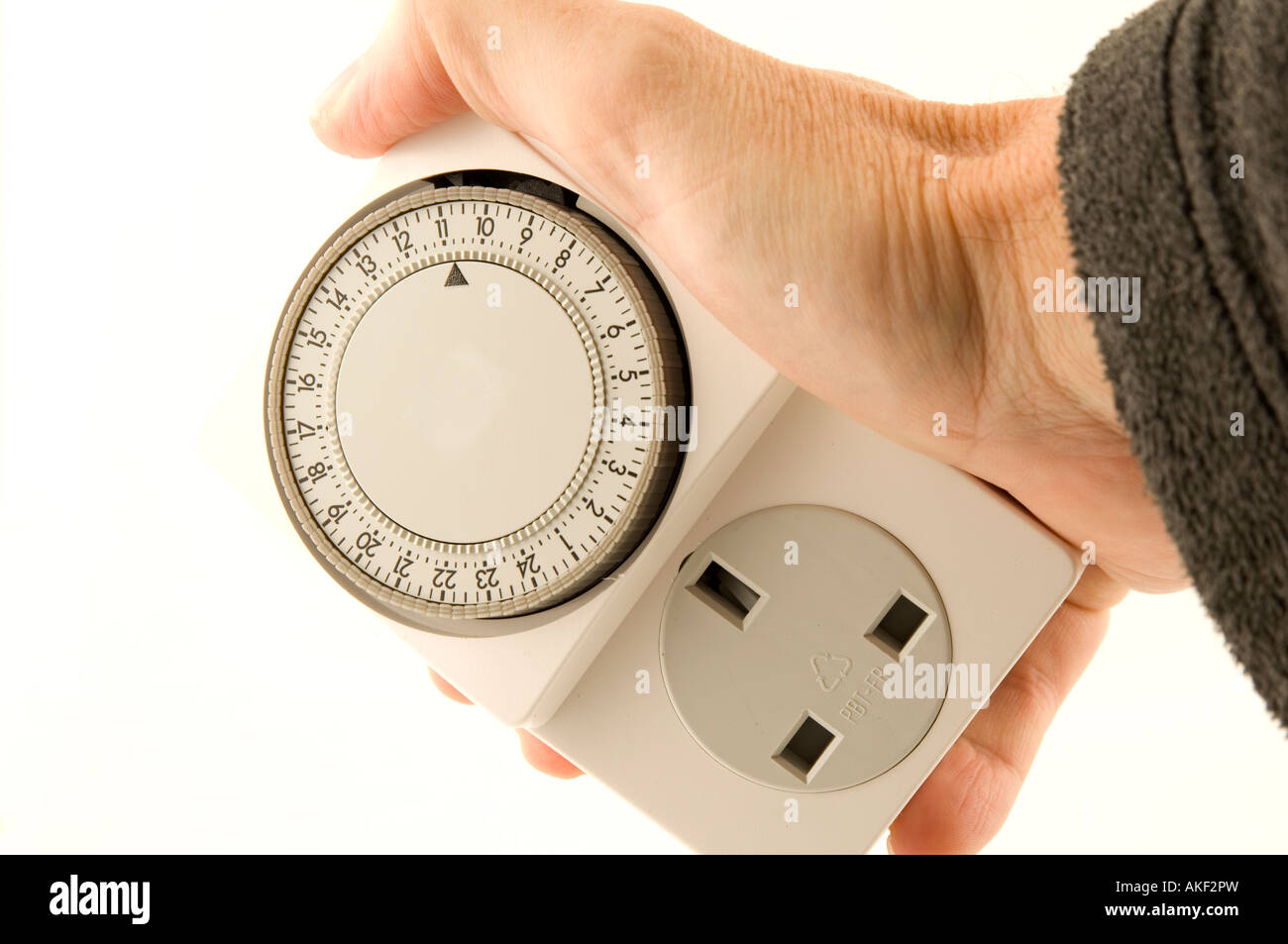 Hand, die eine elektrische Zeitschaltuhr Stockfoto