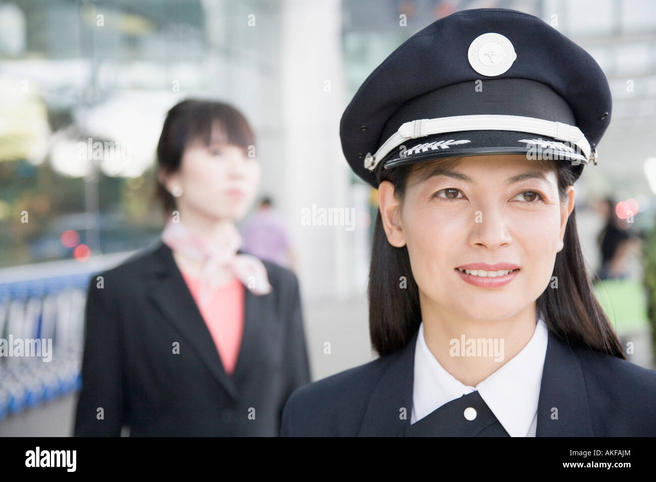 Eine weibliche pilot lächelnd mit einer weiblichen Flugbegleiter hinter ihr in Nahaufnahme Stockfoto