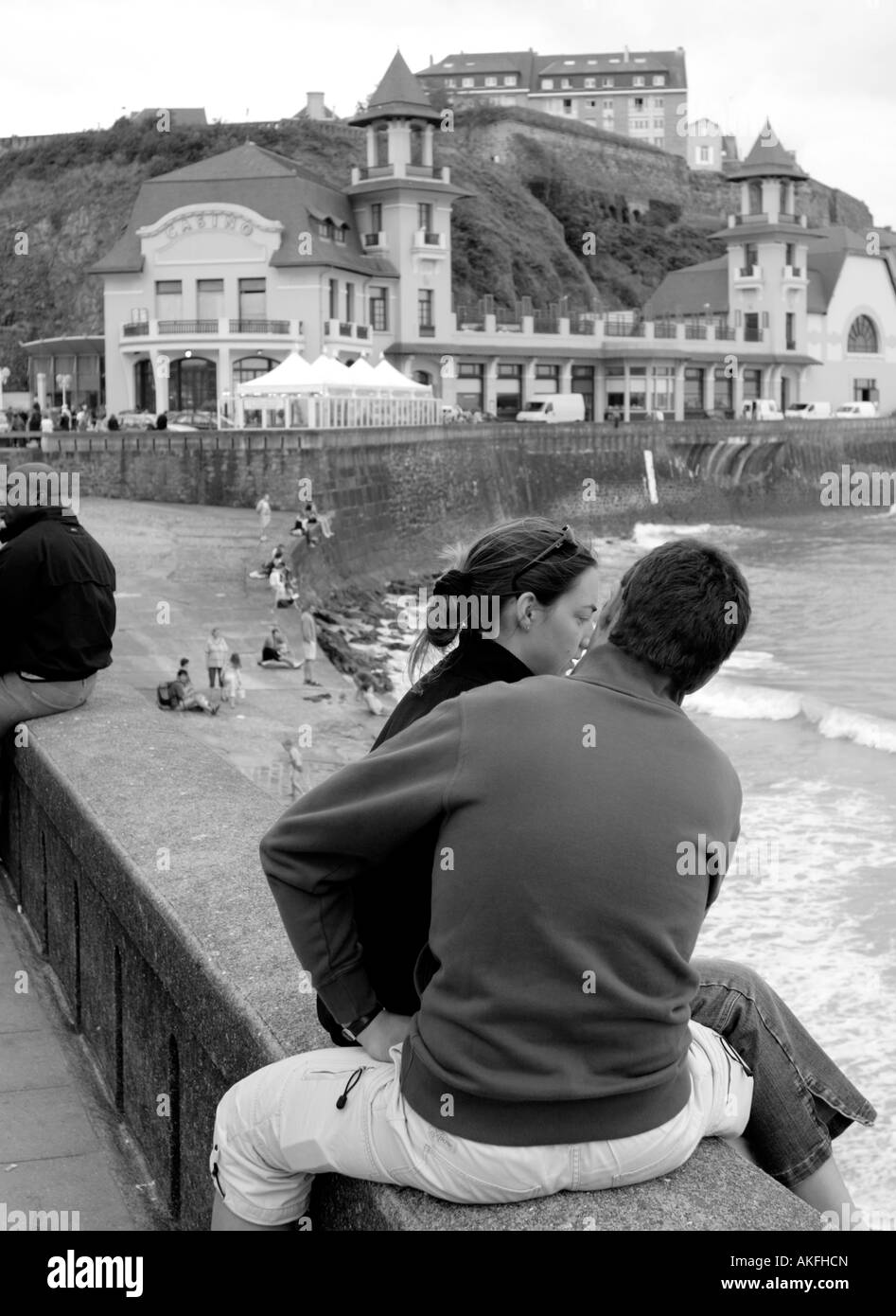 Paar sitzt am Deich mit Casino im Hintergrund Granville La Manche Normandie Frankreich Stockfoto