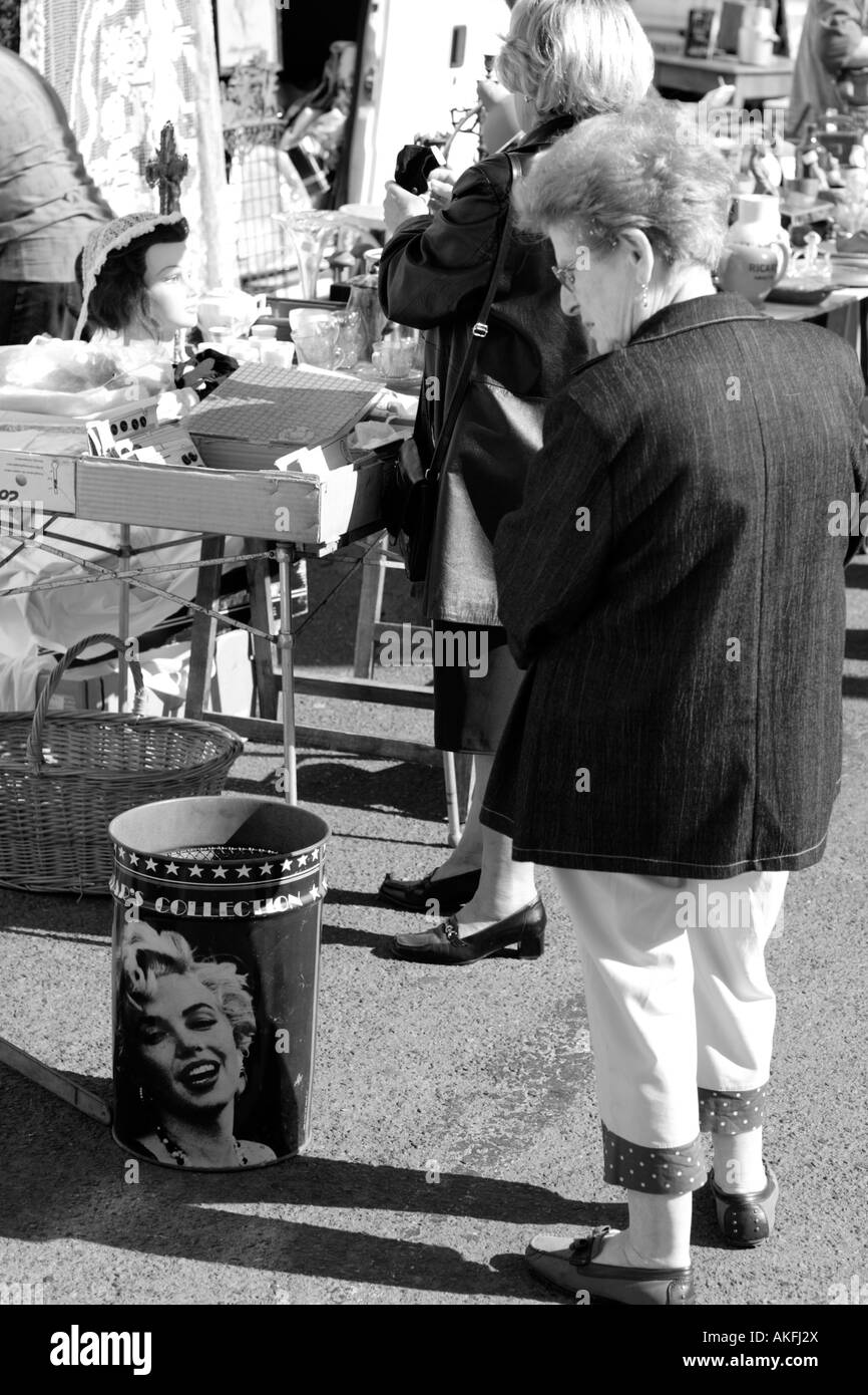 Mittelalter Frau blickte auf Papierkorb mit Porträts von Filmstars auf dem französischen Straße Stockfoto