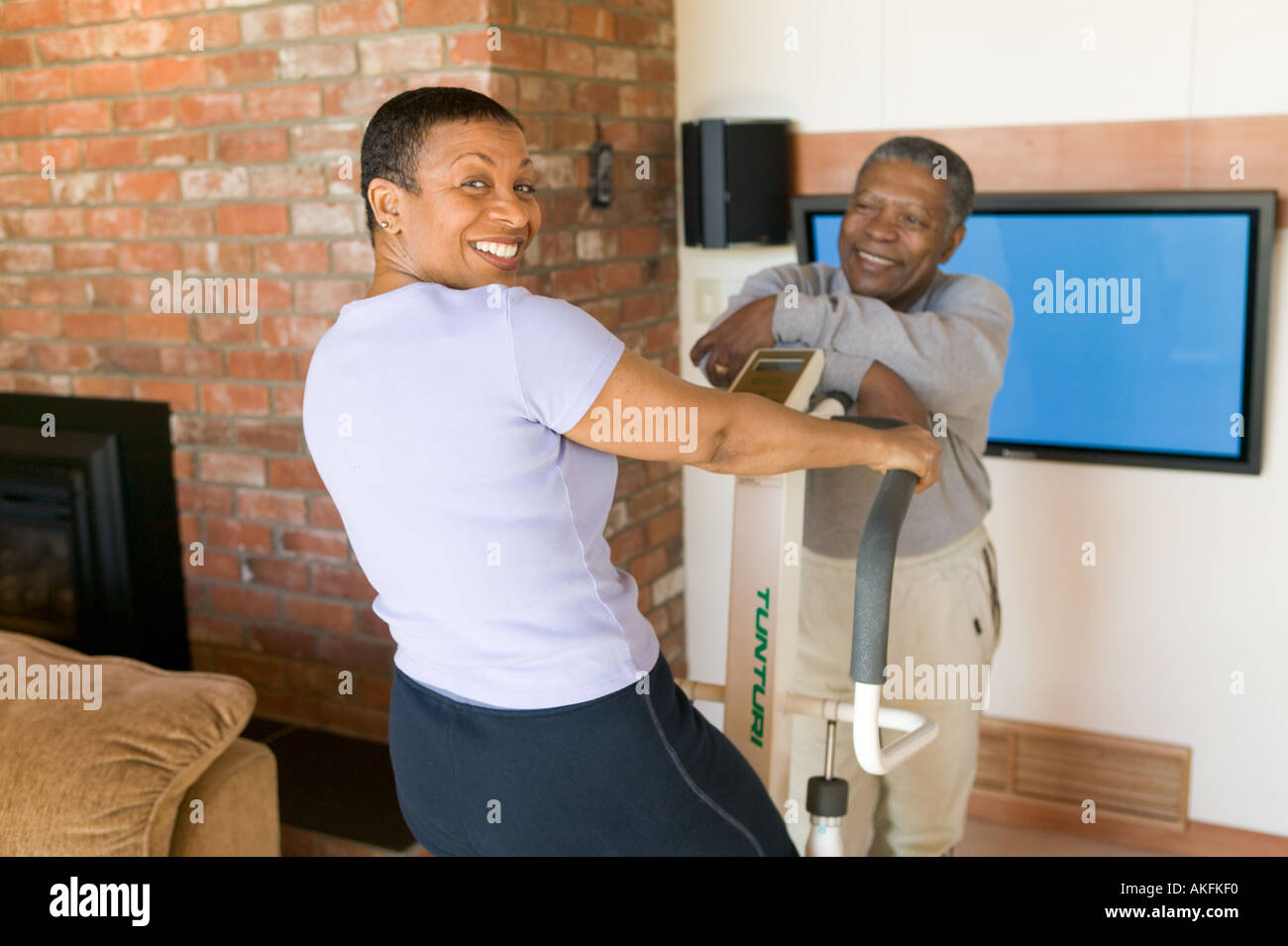 Senioren Training Afro-Amerikaner auf Stepper Maschine und Plasma-TV Stockfoto