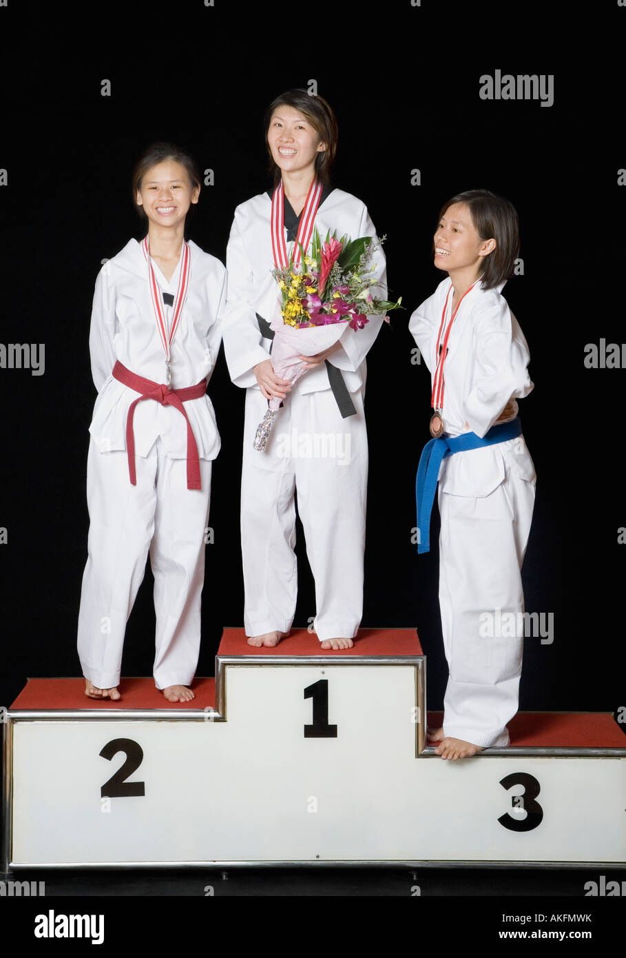 Drei junge Frauen stehen auf einem Podium Gewinner mit ihren Medaillen Stockfoto