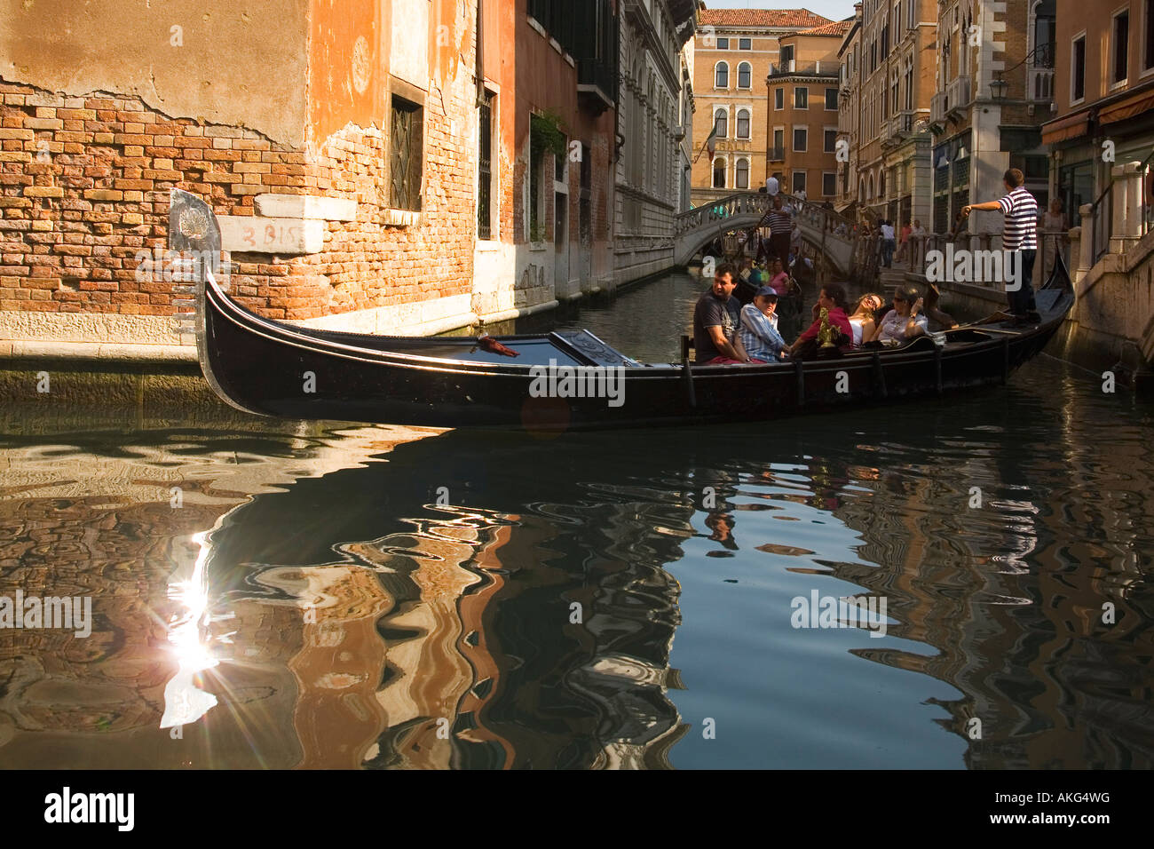 Gondoliere Rudern Touristen aller Seitenkanäle mit Sonne fangen die Eisen Ferro Bug in Venedig Veneto Italien Europa EU Stockfoto