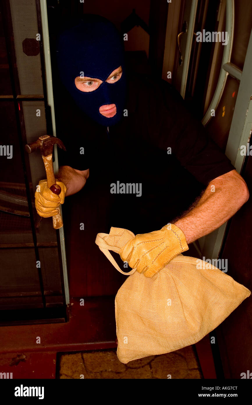 Ein Einbrecher rauben einem Haus eine Sturmhaube tragen. Stockfoto