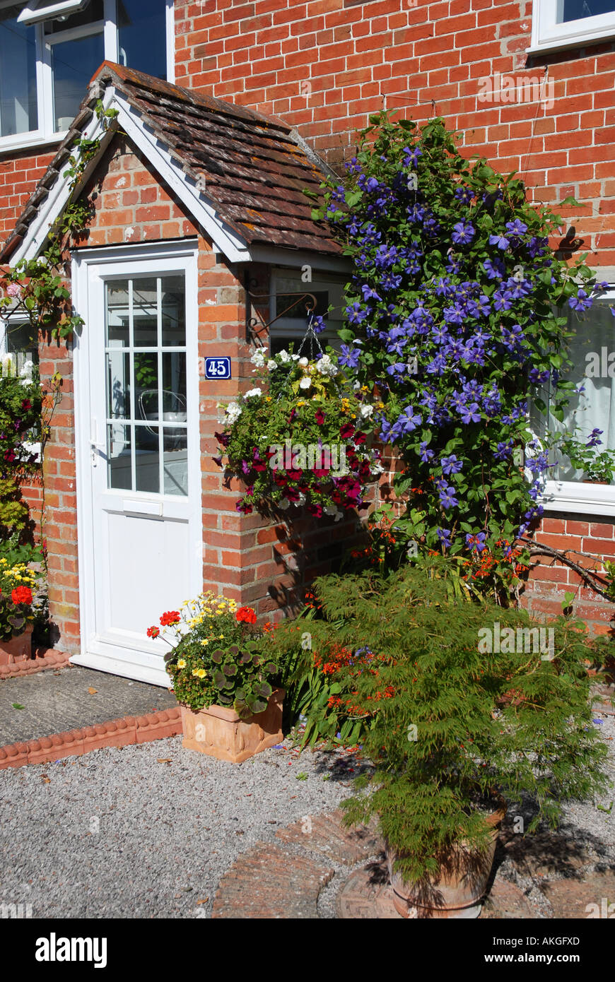 Veranda und Haustür gemauerte Hütte, umgeben von Pflanzen und Blumen Stockfoto