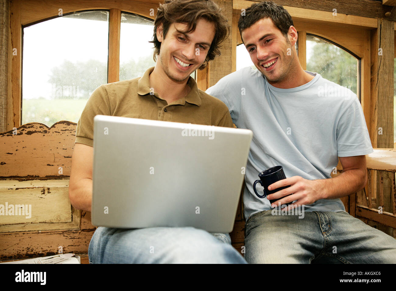 Zwei Männer mit Laptop-Computer vor Fenster ins freie Stockfoto