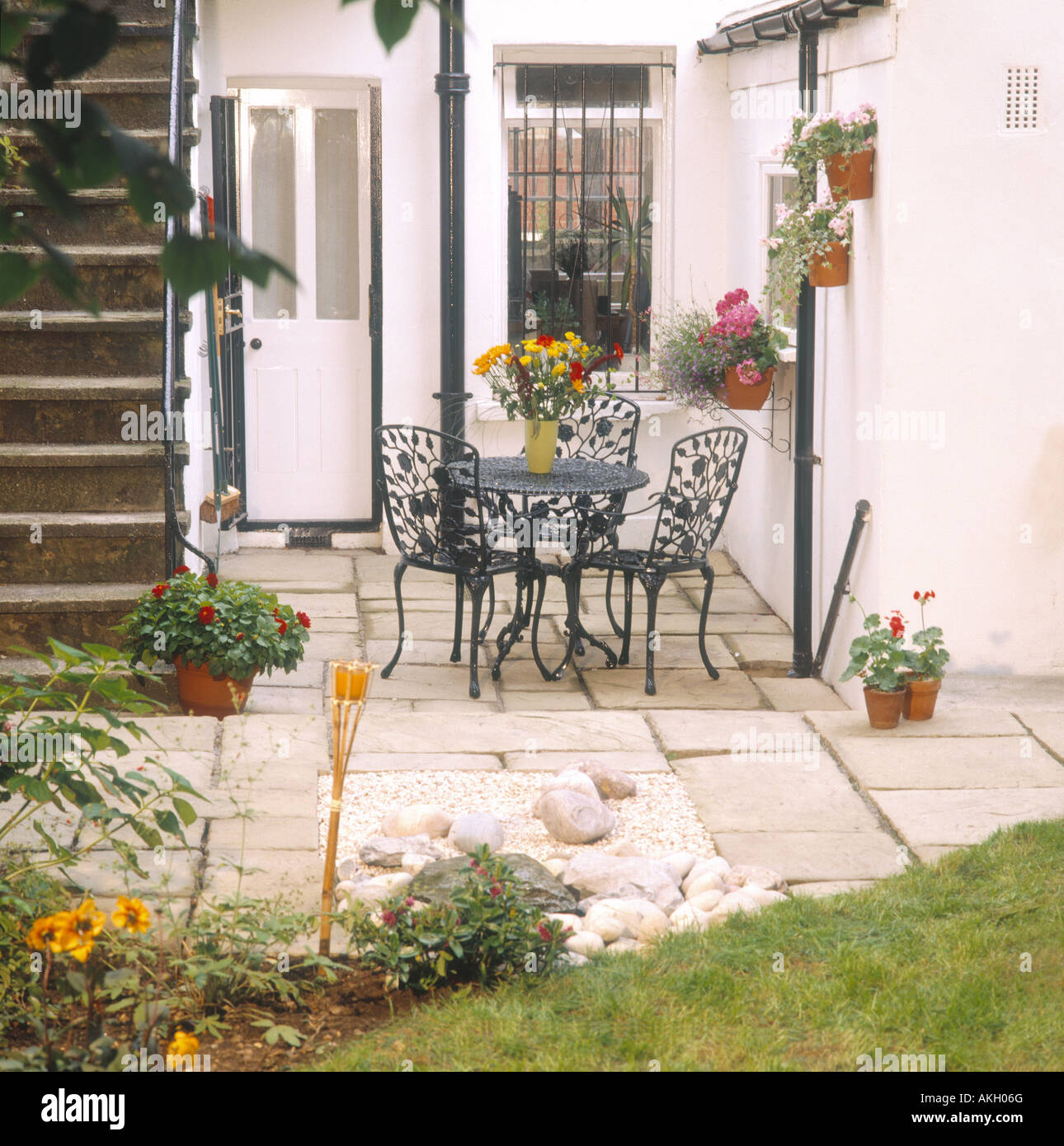 kleinen Garten hinter dem Haus Ost London Eisen Sequenztabelle Stühle Terrasse Steinmauer Töpfe Behälter Stockfoto