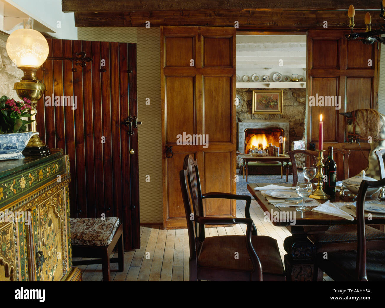 Viktorianischen Lampe auf Sideboard im Esszimmer mit doppelten Türen aus Holz und Blick auf den Kamin im Wohnzimmer Stockfoto