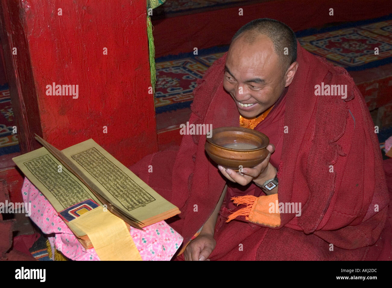 Lama trinkt Tee beim Lesen der Heiligen Schriften an die Dhokham Garther Kloster Kham Sichuan Provinz China Tibet Stockfoto