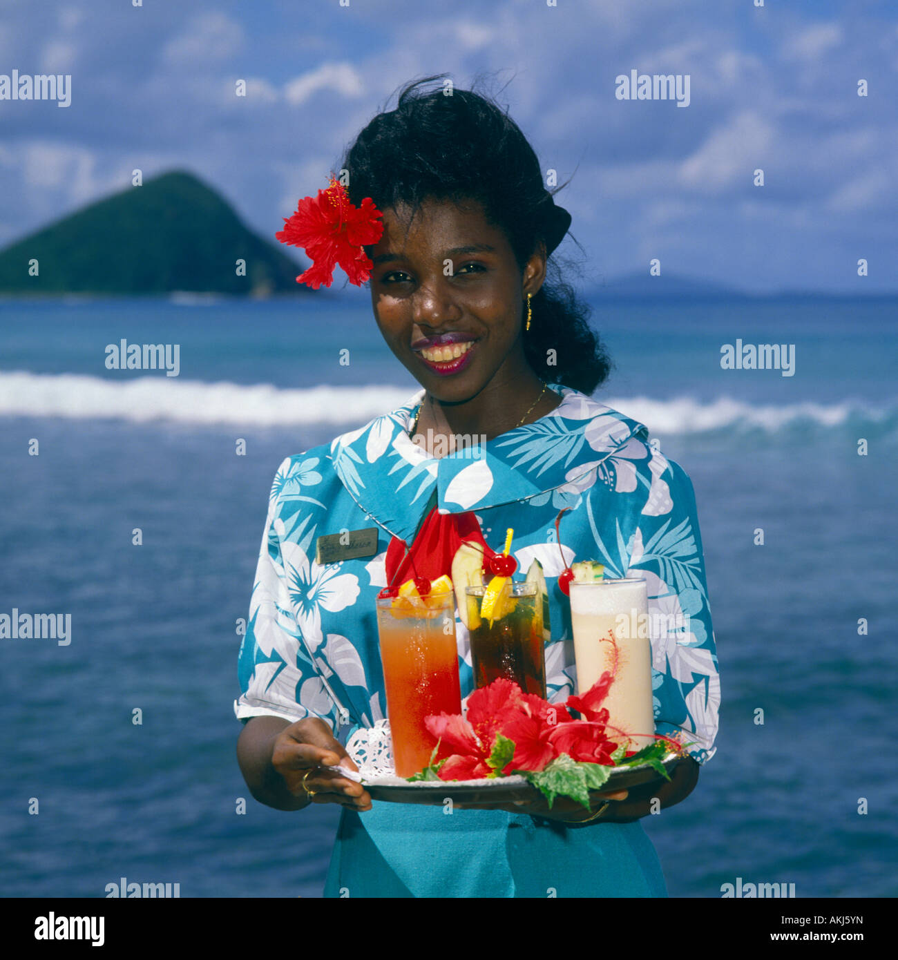 Attraktive lokale Kellnerin hält Tablett mit bunten tropischen Getränke auf Tortola Insel der britischen Jungferninseln West Indies Stockfoto