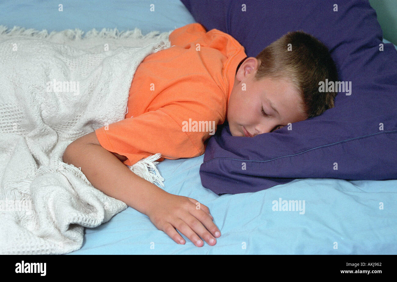 9-jähriger Junge schlafend im Bett Stockfoto