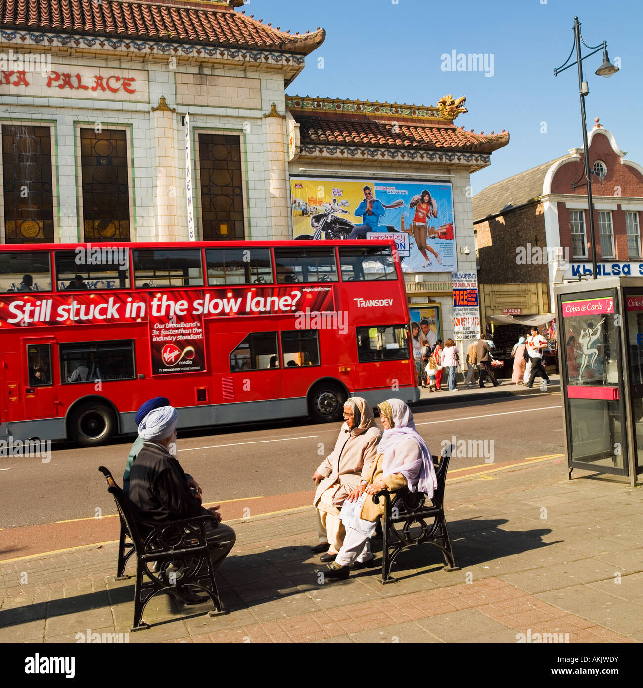 Entspannen in der Sonne gegenüber Himalaya Palast Kino Haus Southall London Sikh Personen im Ruhestand Stockfoto