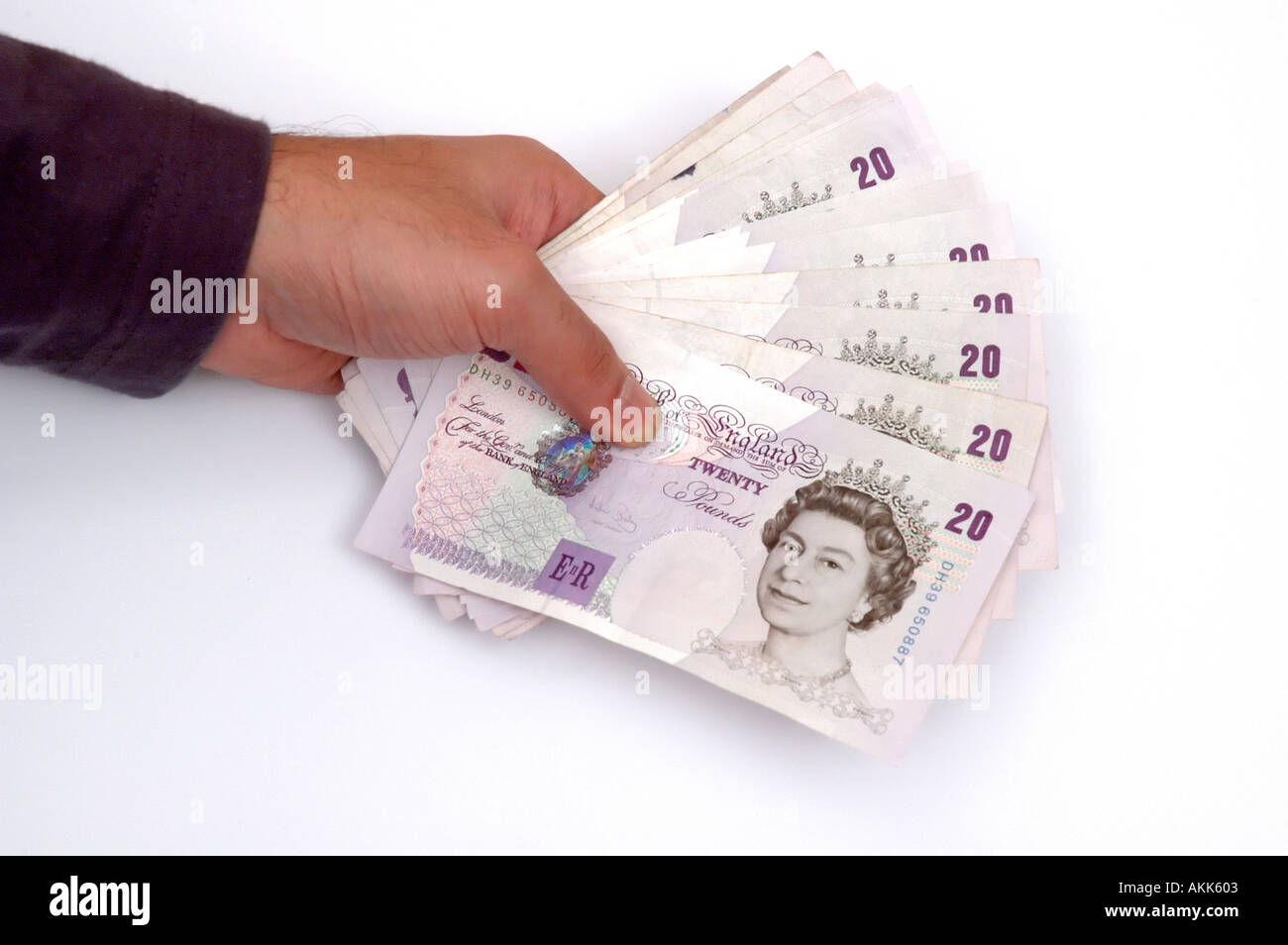Asiatische mans Hand hält viel von 20 Pfund Sterling-Noten auf weißem Hintergrund Stockfoto