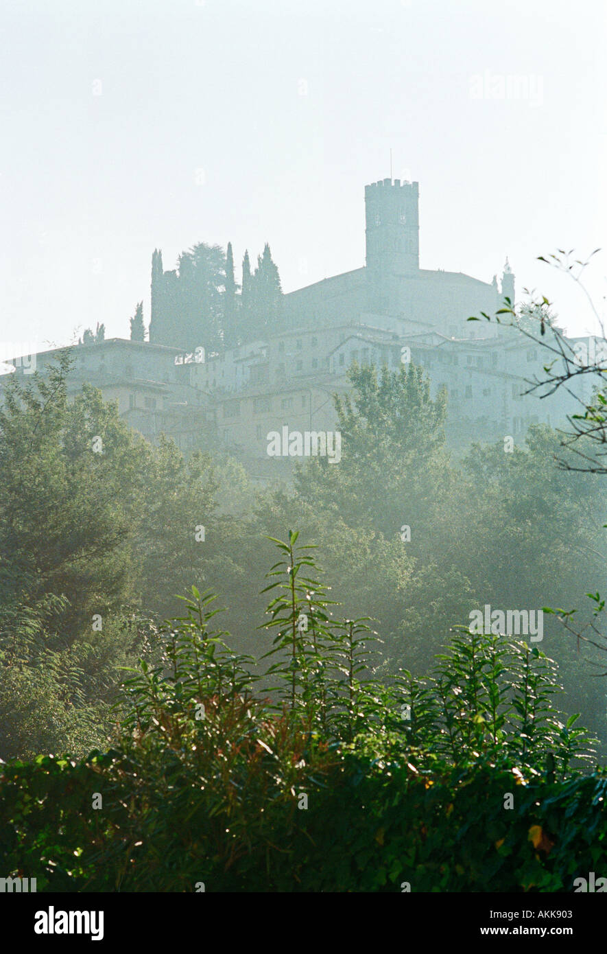 Am frühen Morgennebel hüllt die Hügel Kirche in dem mittelalterlichen Dorf von Barga in den Hügeln der Toskana Italien Stockfoto