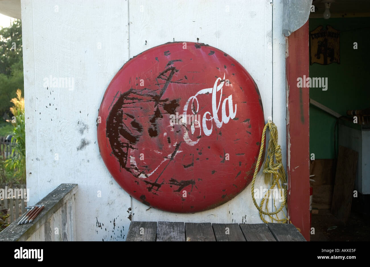 Alte Coca Cola Schlitten hängt an einem Schuppen Stockfoto