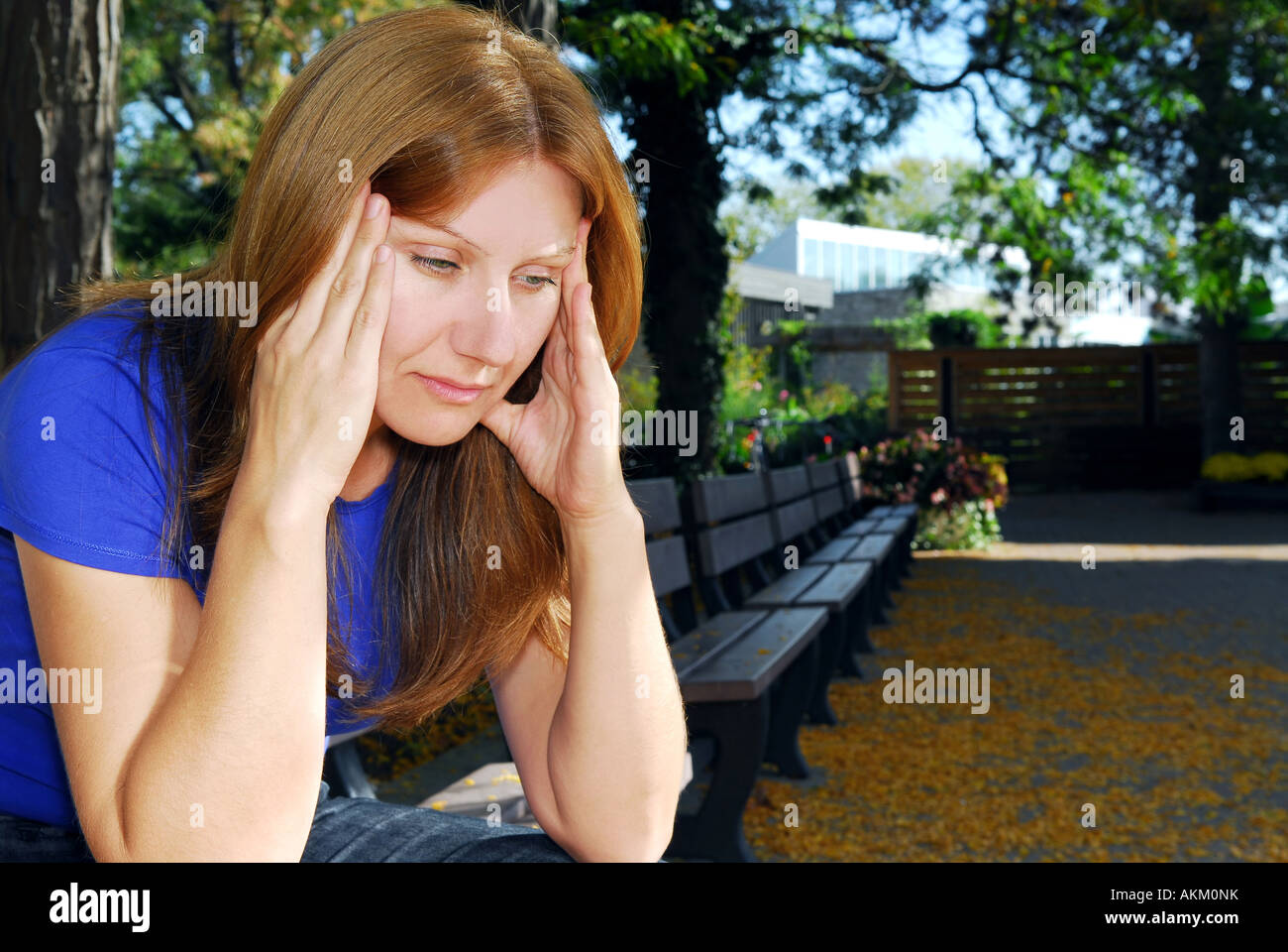 Reife Frau mit Kopfschmerzen auf der Parkbank sitzen Stockfoto