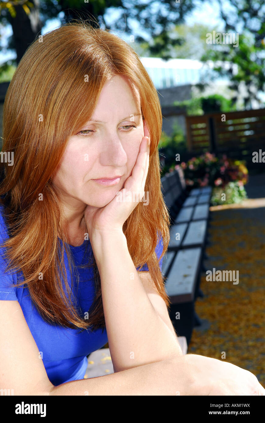Reife Frau sucht, traurig und deprimiert allein auf einer Parkbank sitzen Stockfoto