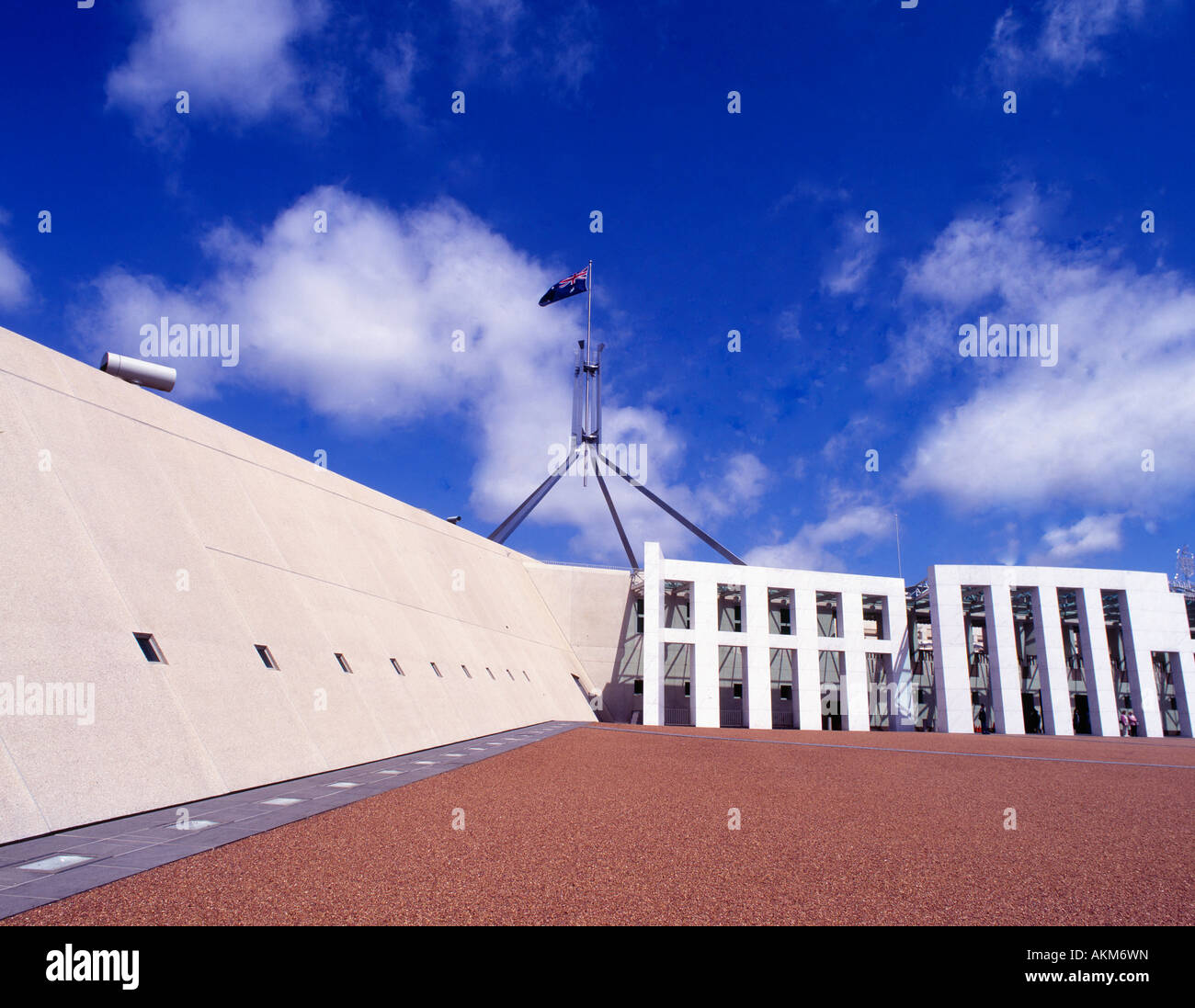 Außenansicht des Australian Parliament House unter einem wolkenblauen Himmel mit der Nationalflagge, die auf Canberra ACT Australia winkt Stockfoto