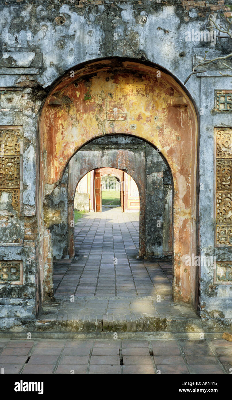 Imperial-Gehäuse, verwitterte Hung Temple Tor Bögen durch betrachtet Wandöffnung gewölbt, Hue, Vietnam Stockfoto