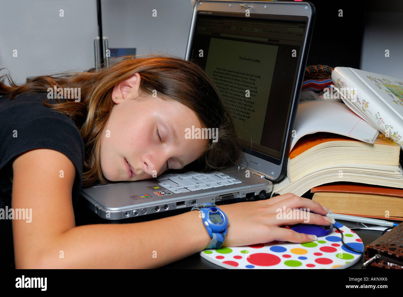 Junges Mädchen mit Kopf auf Laptop-Computer in ihrem Schlafzimmer schläft erschöpft Stockfoto