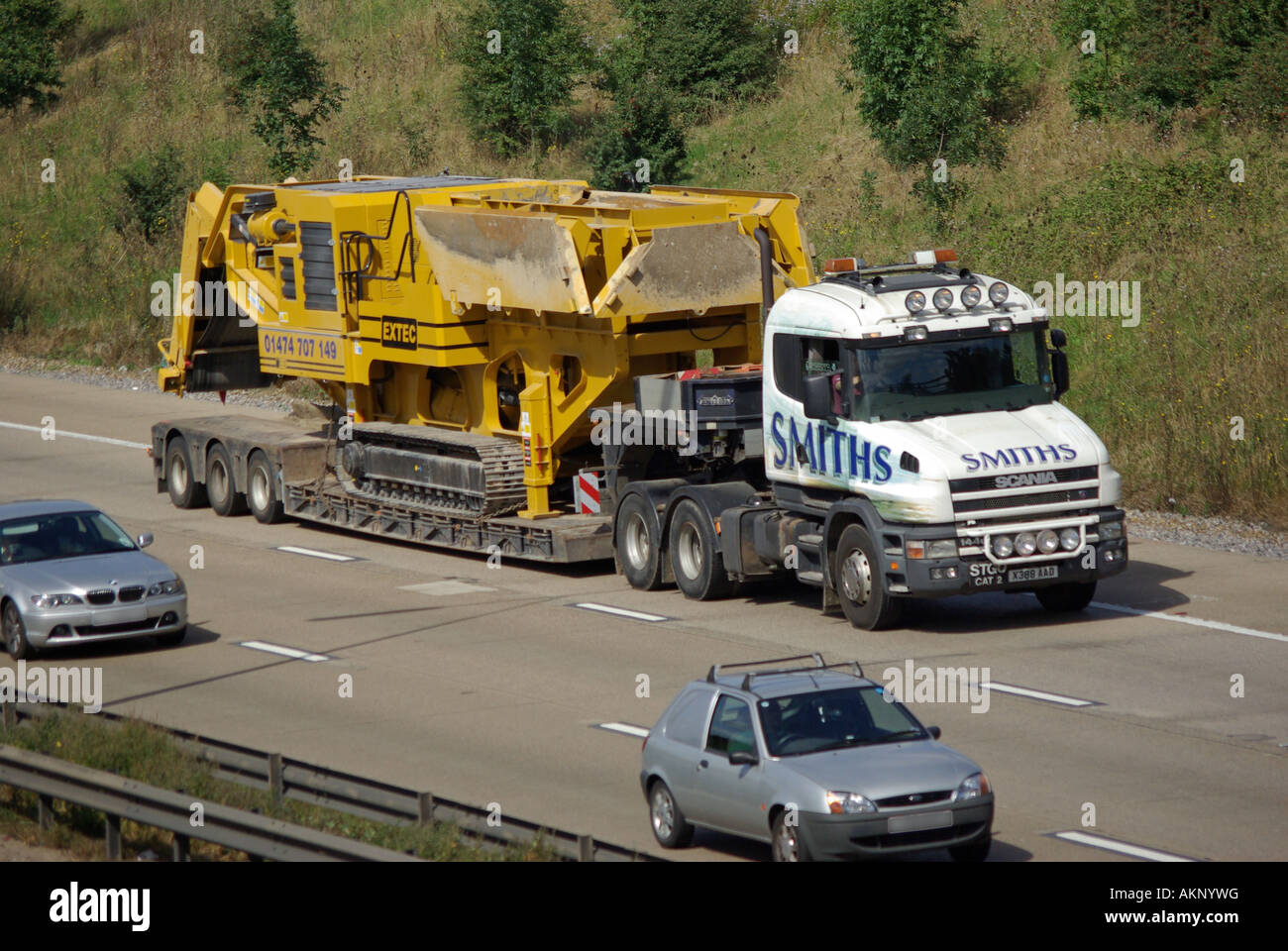 Verkehr vorbei langsam fahrenden SCANIA Bonnet LKW Smiths Schwertransport Tieflader Anhänger große Maschinenladung Fahren entlang Autobahn England Großbritannien Stockfoto Verkehr vorbei langsam fahrenden SCANIA Bonnet LKW Smiths Schwertransport Tieflader Anhänger große Maschinenladung Fahren entlang Autobahn England Großbritannien Stockfoto