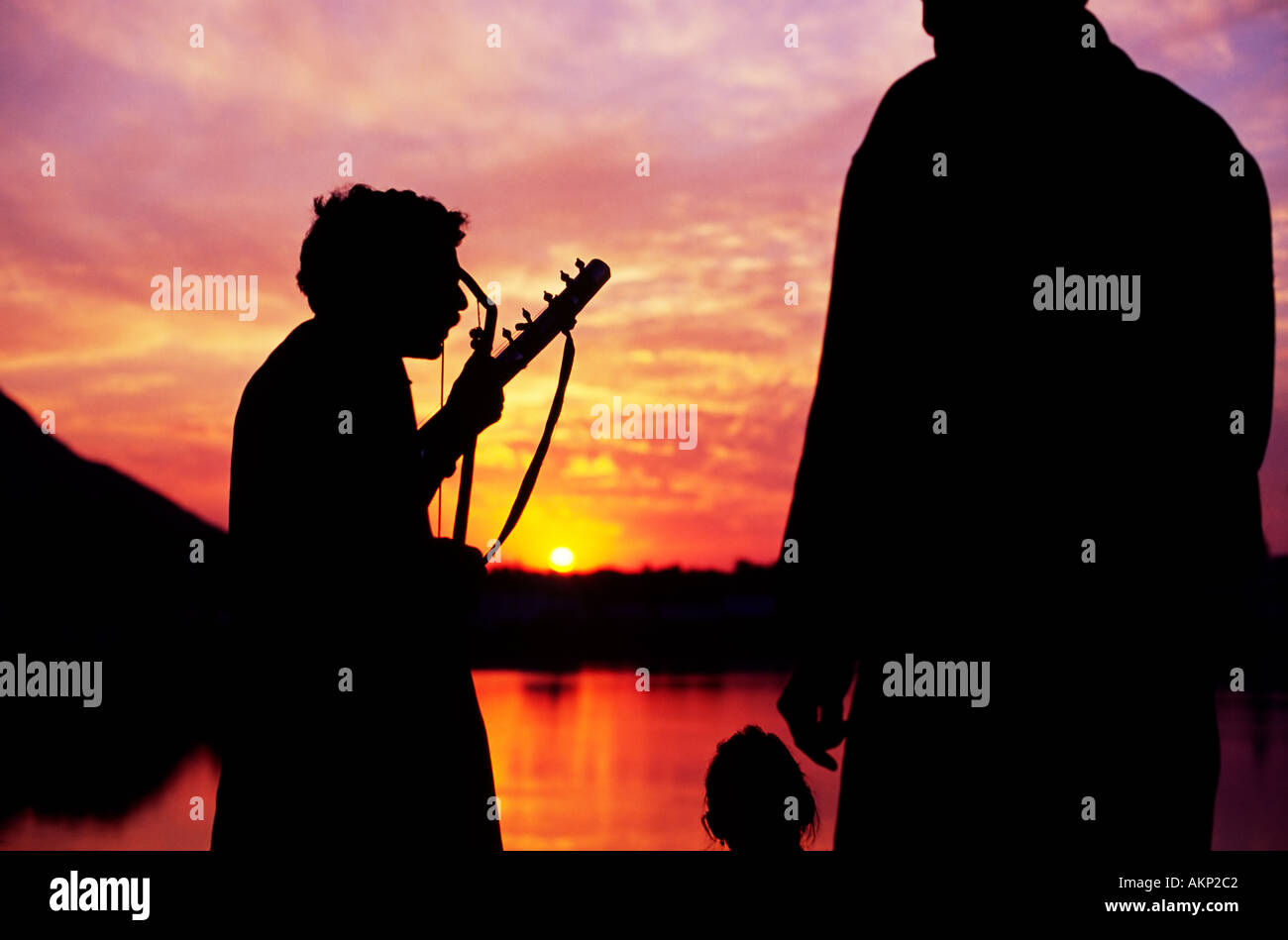 Silhouette vor einem Sonnenuntergang Himmel von zwei Personen mit indischen Musikinstrument TARSHEHNAI Stockfoto