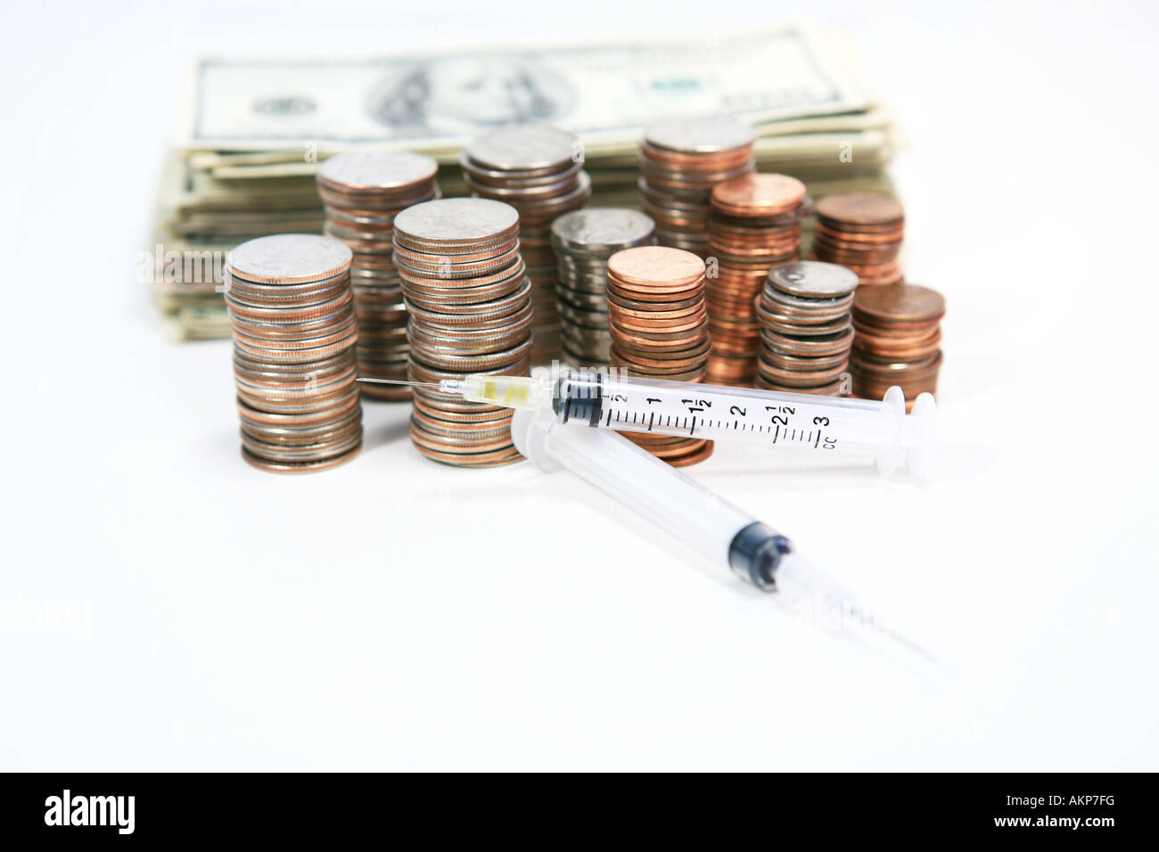 Zwei Spritzen mit Nadeln auf Haufen von amerikanisches Geld Münzen und Cash, isoliert Stockfoto