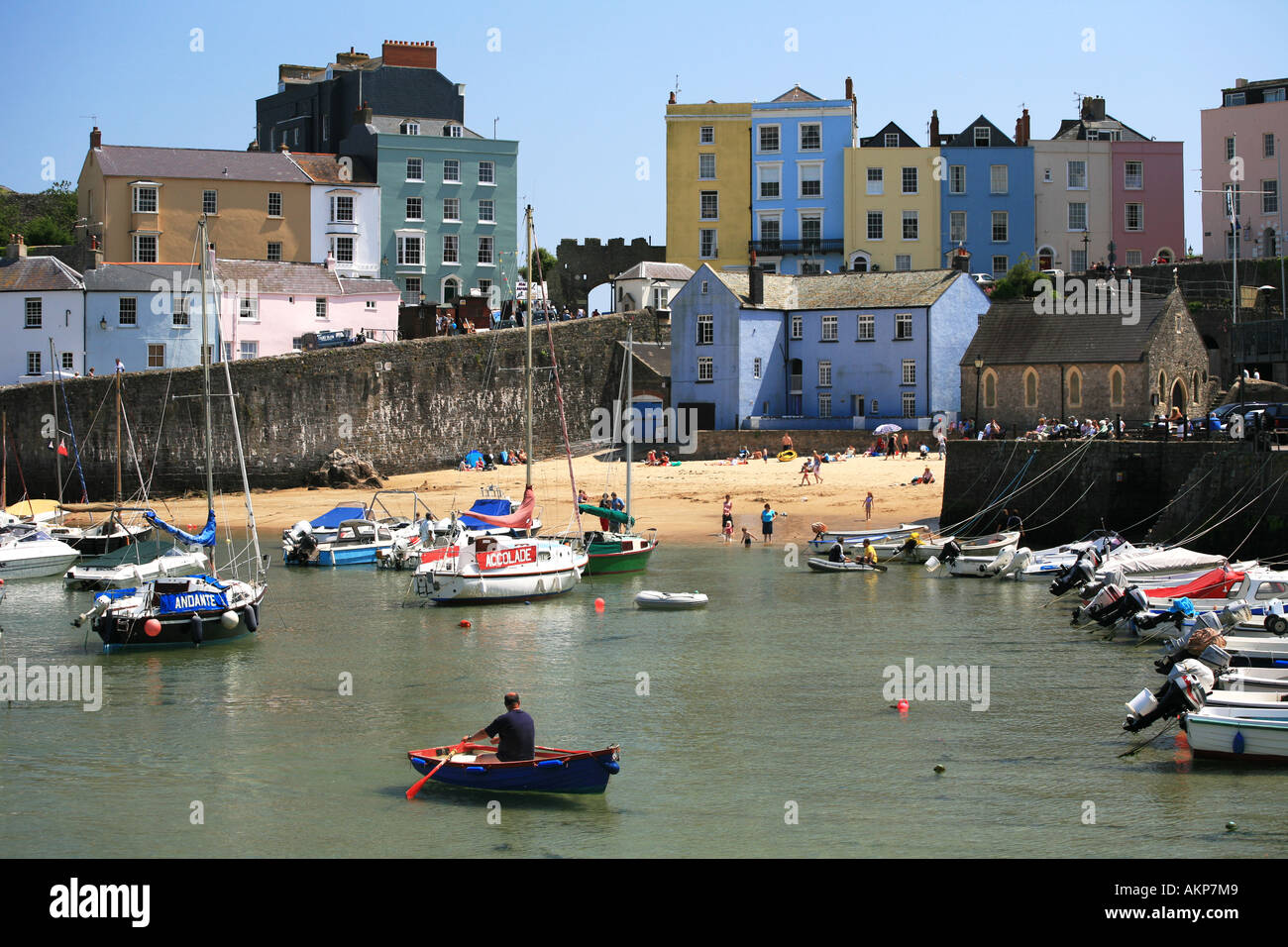 Tenbys berühmte Pastell gemalt Gebäude Stand hinter dem kleinen inneren Hafen mit kleinen Booten Pembrokeshire West Wales Großbritannien Stockfoto