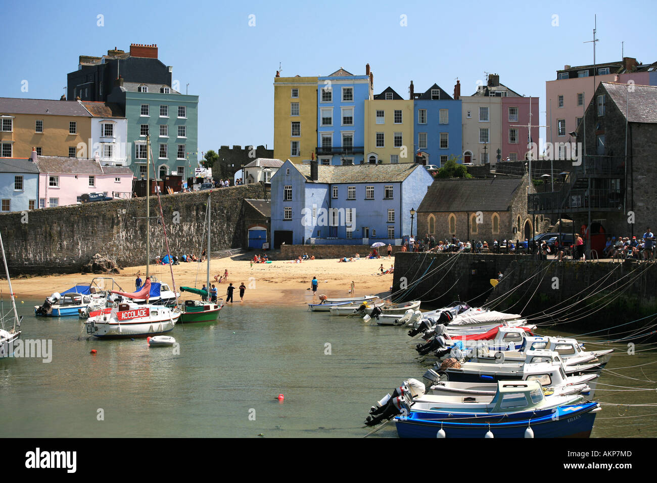 Tenby des berühmten Pastell gemalt Gebäude Stand hinter dem kleinen inneren Hafen mit kleinen Booten Pembrokeshire West Wales Großbritannien Stockfoto