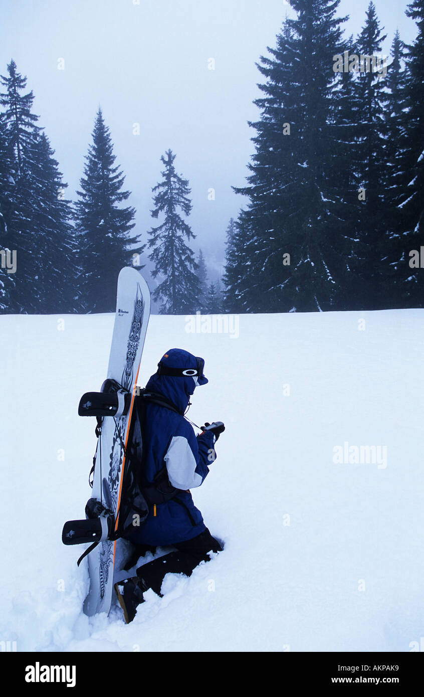 Snowboarder prüft GPS im Wald Schnee-Sturm Stockfoto