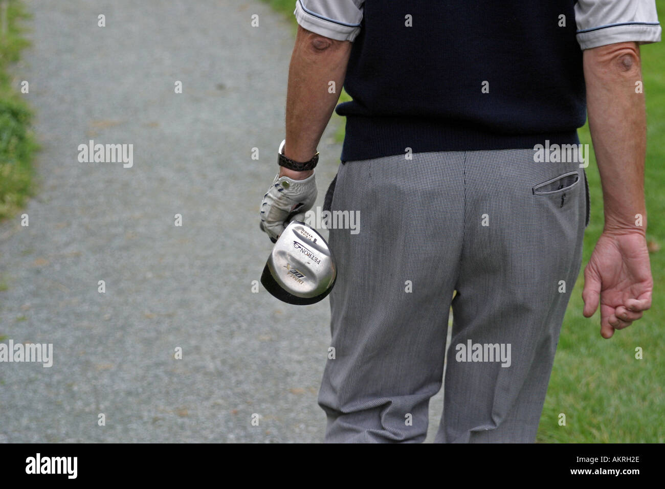 Golfer, die zu Fuß einen Weg zum Abschlag aus-Stellung mit einem Holz in der hand Stockfoto