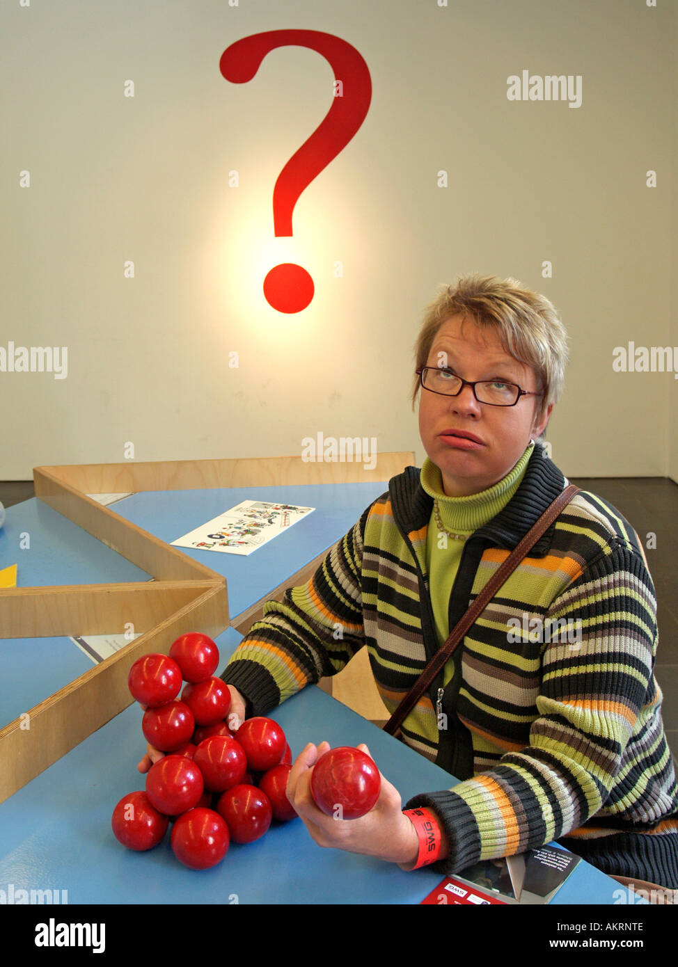 Frau versucht, eine Pyramide aus verschiedenen Stücken knifflige bauen spielen für die Intelligenz im Museum Mathematikum gießen Stockfoto