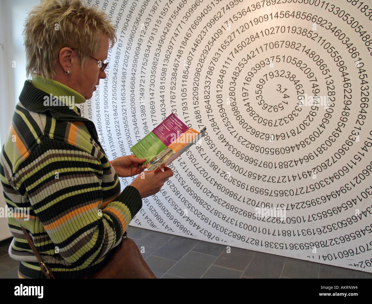 Frau, die eine Zeichnung mit den endlosen Zahl Pi in Form einer Helix an der Wand im Museum Mathematikum Giessen Deutschland Stockfoto