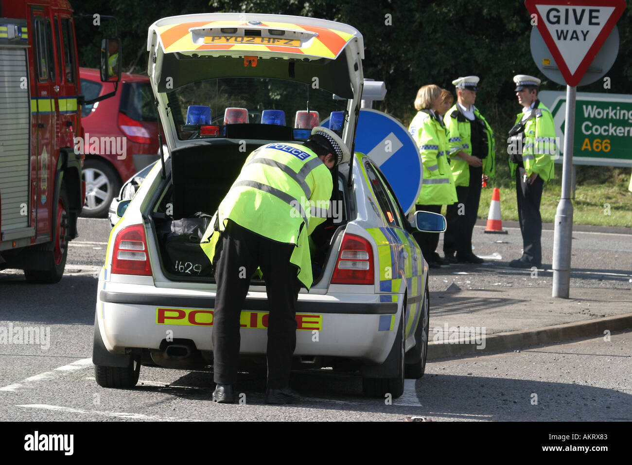 Polizist auf der Rückseite ein Polizeiauto nach Verkehrsunfall Stockfoto