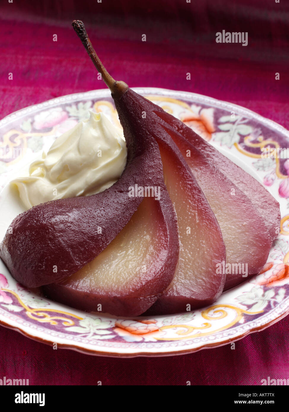 Ein Teller mit pochierten Birnen in Rotwein mit Crème Fraiche redaktionelle Feinkost Stockfoto